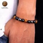 Hombre luciendo pulsera ojo de tigre 17cm con detalles de hematita y obsidiana