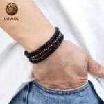 Hombre con pulsera triple protección Oeil de cuero negro y piedra roja